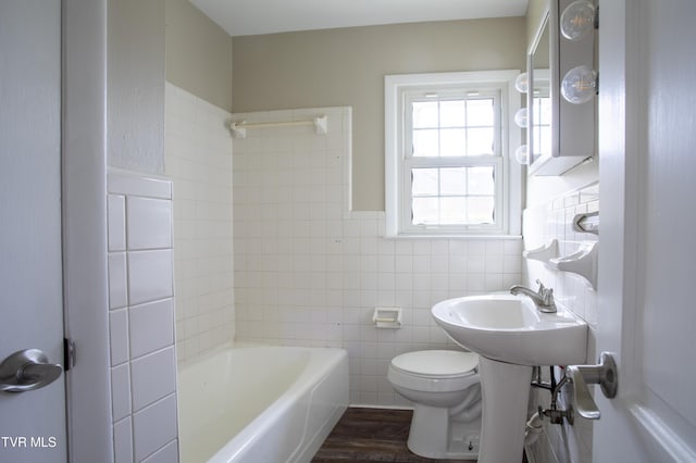 bathroom with hardwood / wood-style floors, toilet, and tile walls