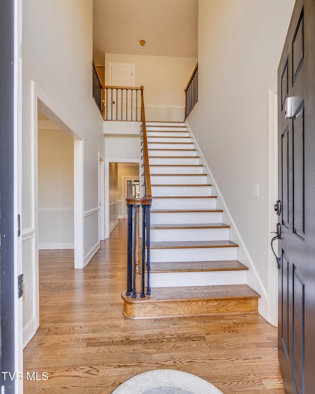 foyer entrance featuring light hardwood / wood-style floors and a high ceiling