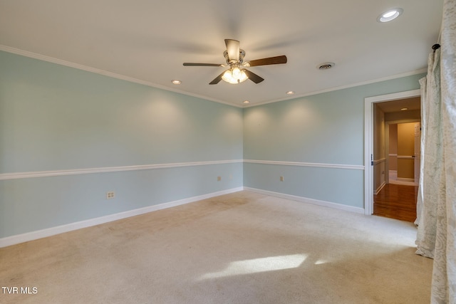 carpeted spare room featuring ceiling fan and ornamental molding