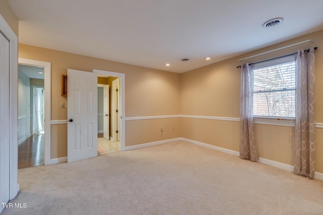 unfurnished room featuring light colored carpet