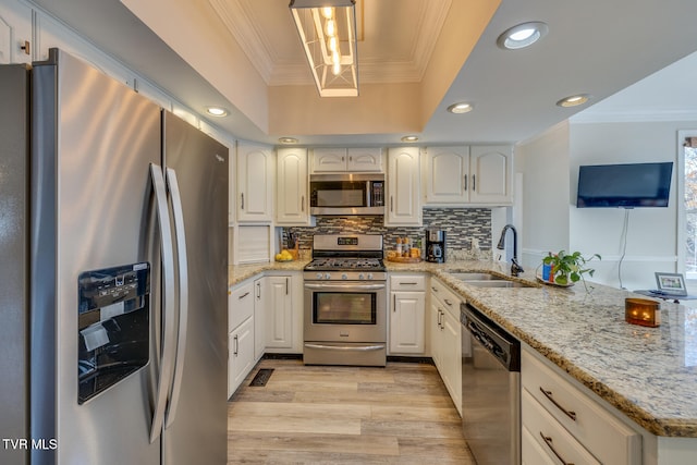 kitchen with pendant lighting, sink, white cabinetry, and stainless steel appliances