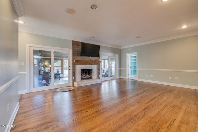 unfurnished living room with plenty of natural light, light wood-type flooring, and a brick fireplace