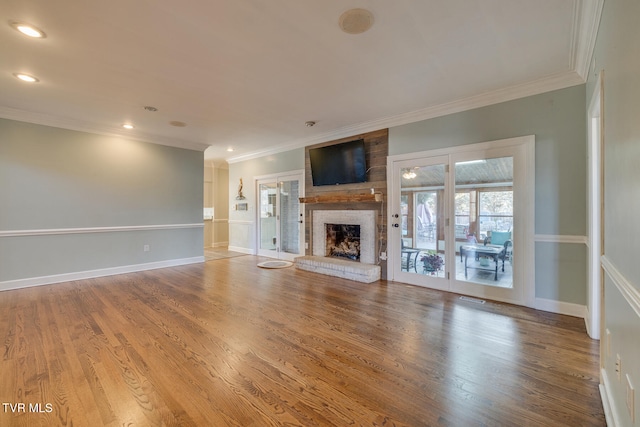 unfurnished living room featuring crown molding, wood-type flooring, and a fireplace