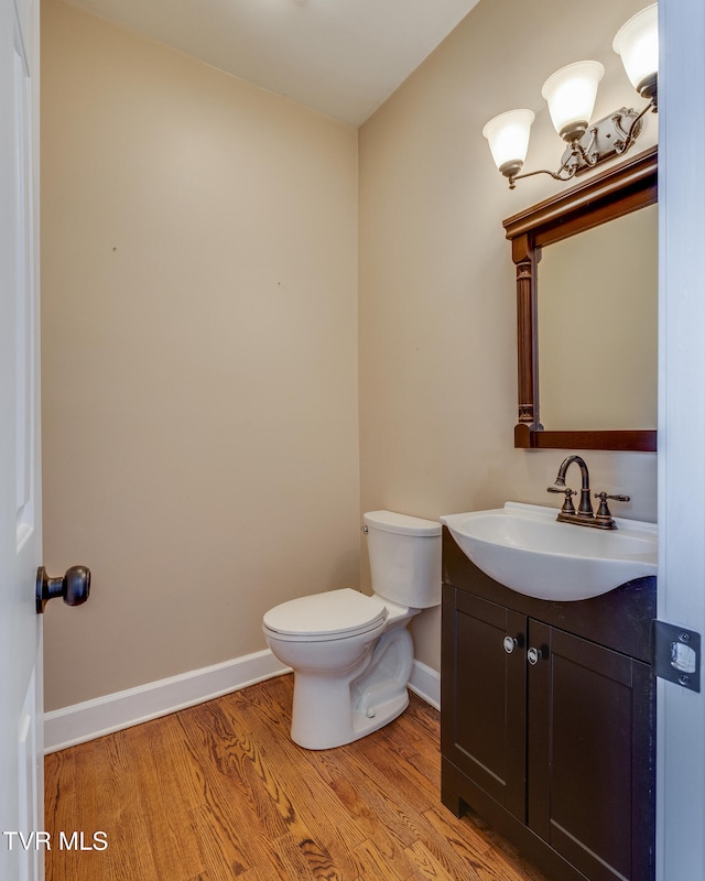 bathroom featuring vanity, wood-type flooring, and toilet