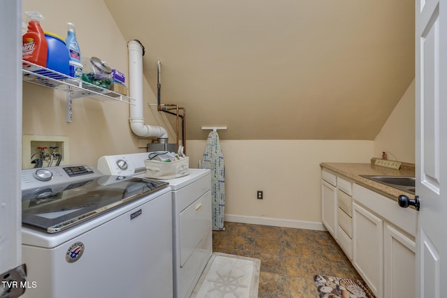 laundry area featuring washer and dryer, cabinets, and sink