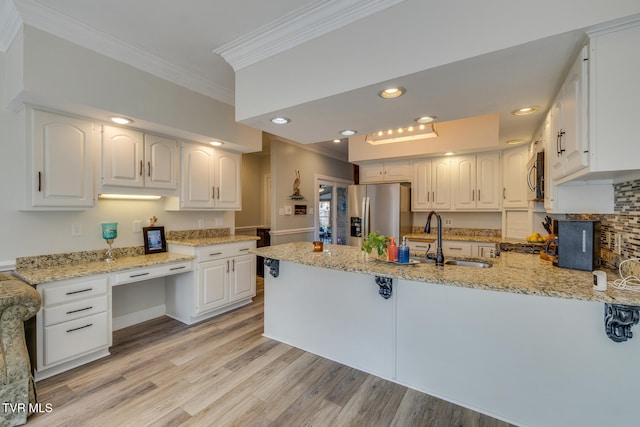 kitchen featuring white cabinets, light hardwood / wood-style floors, light stone countertops, and stainless steel appliances