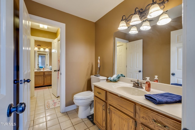 bathroom featuring tile patterned flooring, vanity, and toilet