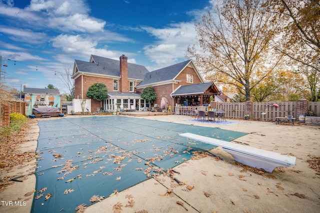 view of swimming pool with a diving board and a patio