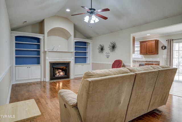 living room with vaulted ceiling, light hardwood / wood-style flooring, and ceiling fan