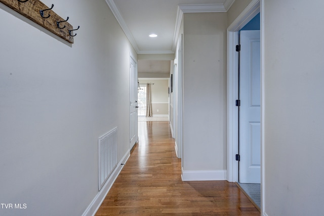 hallway featuring crown molding and light hardwood / wood-style flooring