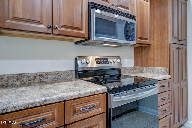 kitchen with tile patterned floors and appliances with stainless steel finishes