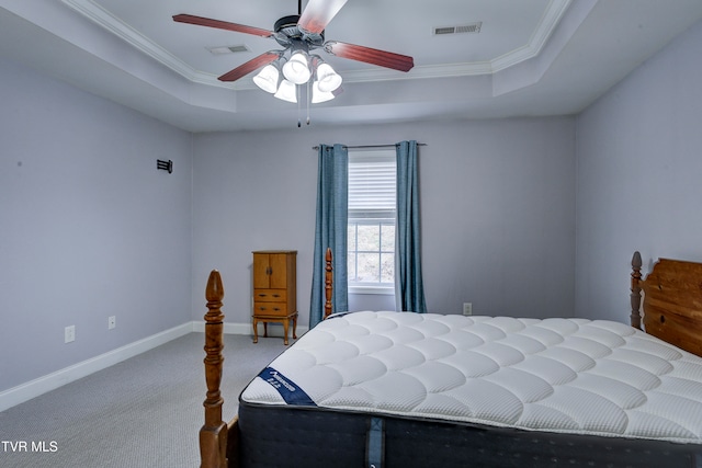 bedroom with carpet flooring, a tray ceiling, ceiling fan, and crown molding