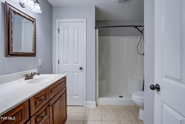 bathroom with a shower, vanity, tile patterned floors, and toilet