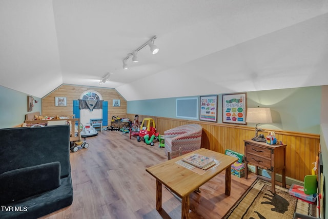 playroom with hardwood / wood-style flooring, vaulted ceiling, and wood walls