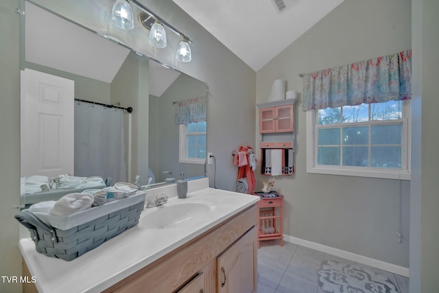 bathroom featuring tile patterned floors, vanity, and lofted ceiling