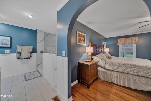 bedroom featuring a textured ceiling, wood-type flooring, and crown molding