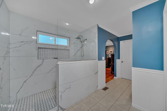 bathroom with tile patterned flooring and a tile shower