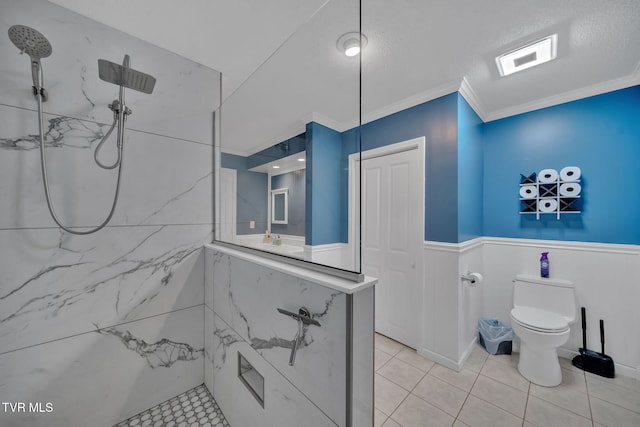 bathroom featuring crown molding, toilet, a textured ceiling, and a tile shower