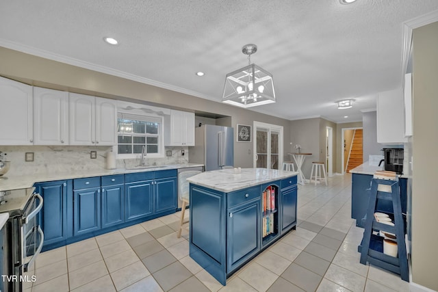 kitchen featuring stainless steel appliances, blue cabinets, sink, white cabinetry, and hanging light fixtures