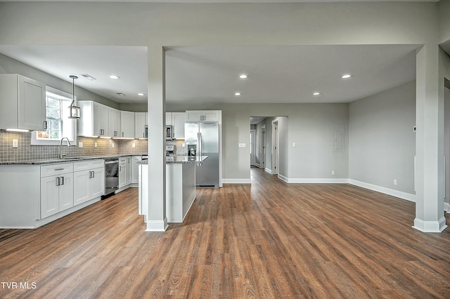 kitchen featuring stainless steel appliances, white cabinetry, dark hardwood / wood-style floors, and decorative light fixtures