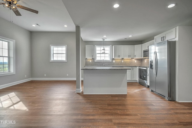 kitchen with sink, dark wood-type flooring, appliances with stainless steel finishes, white cabinetry, and decorative backsplash