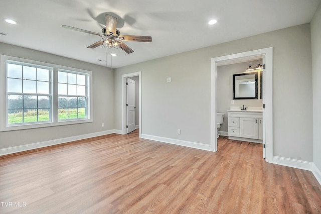 unfurnished bedroom with connected bathroom and light hardwood / wood-style flooring