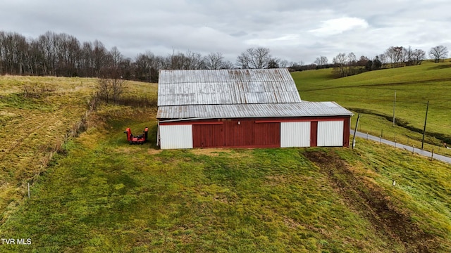 view of outbuilding with a rural view and a lawn