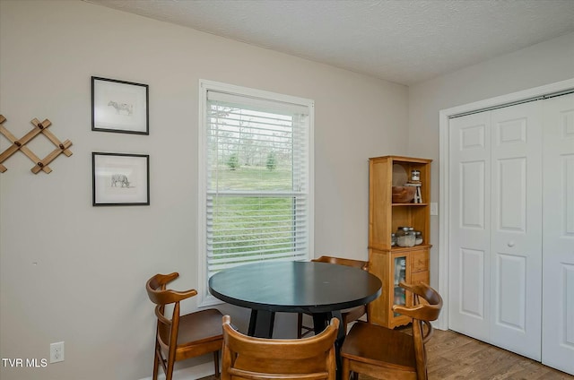 dining space featuring a textured ceiling and light wood-type flooring