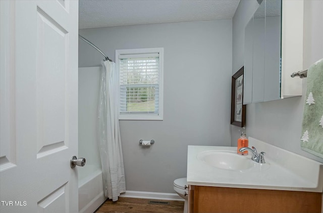 full bathroom featuring hardwood / wood-style floors, vanity, toilet, shower / bathtub combination with curtain, and a textured ceiling