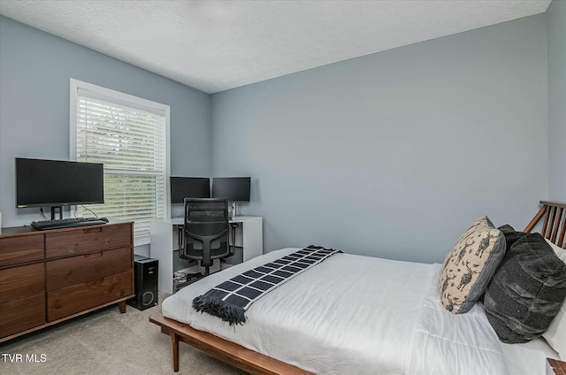 bedroom featuring light colored carpet and a textured ceiling