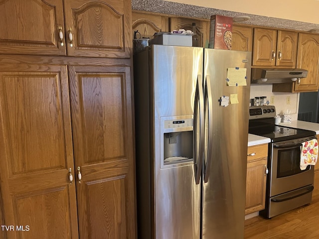 kitchen with appliances with stainless steel finishes and light hardwood / wood-style flooring