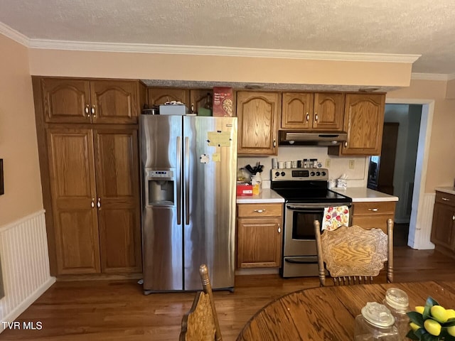 kitchen with appliances with stainless steel finishes, a textured ceiling, dark hardwood / wood-style floors, and ornamental molding