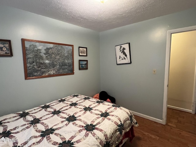 bedroom featuring a textured ceiling and dark wood-type flooring