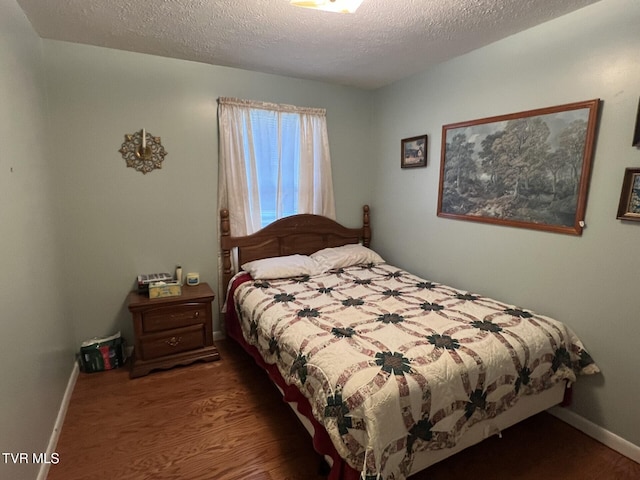 bedroom featuring a textured ceiling and hardwood / wood-style flooring