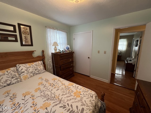 bedroom with dark wood-type flooring and a textured ceiling