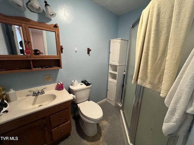 bathroom with vanity, a shower with shower door, and toilet