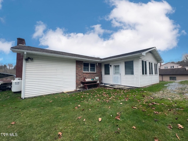 rear view of house featuring a yard