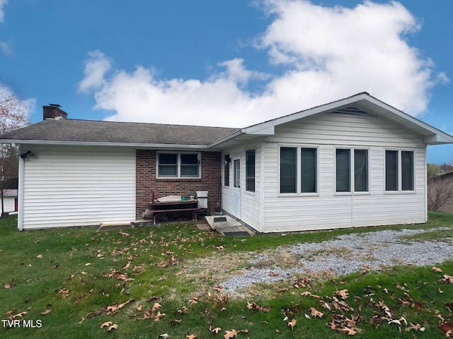 rear view of property featuring a yard