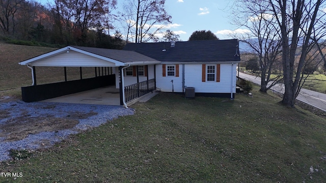 view of front of home with central AC unit, a front yard, and a carport