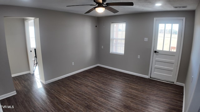 foyer entrance with ceiling fan and dark wood-type flooring