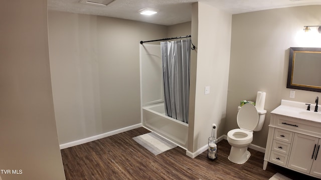 full bathroom with a textured ceiling, vanity, shower / tub combo with curtain, hardwood / wood-style flooring, and toilet