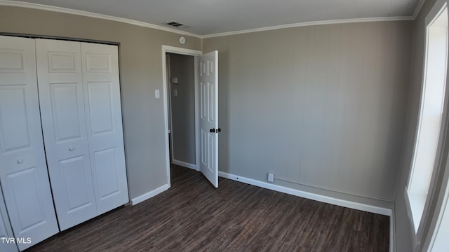 unfurnished bedroom featuring dark hardwood / wood-style floors, a closet, and crown molding