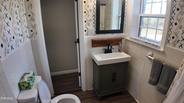 bathroom with hardwood / wood-style floors, vanity, tile walls, and toilet