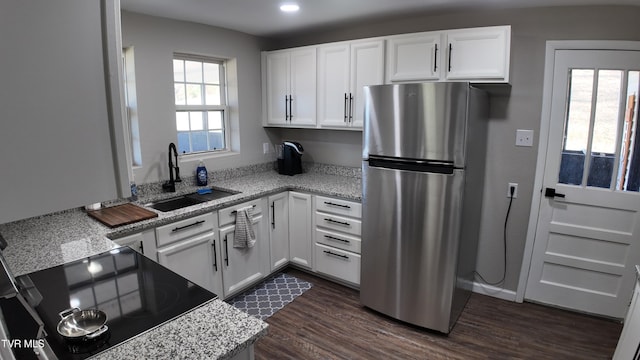 kitchen featuring stainless steel fridge, white cabinetry, plenty of natural light, and sink