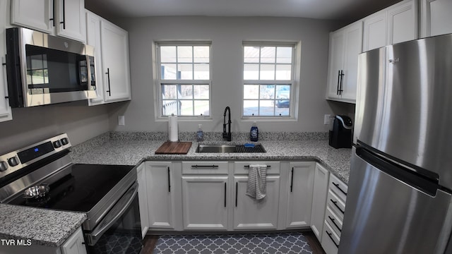 kitchen with sink, white cabinets, and stainless steel appliances