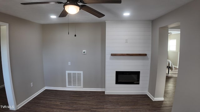 unfurnished living room with a fireplace, dark hardwood / wood-style floors, and ceiling fan