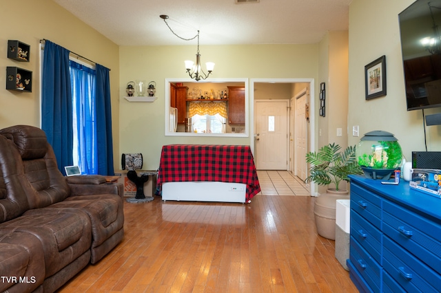 living room with light hardwood / wood-style flooring and a notable chandelier