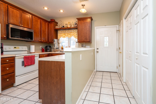 kitchen with light tile patterned floors, a textured ceiling, and white range with electric stovetop