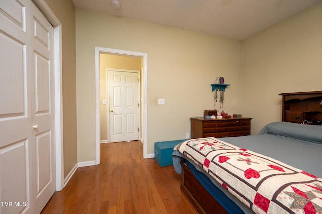 bedroom featuring hardwood / wood-style flooring, a textured ceiling, and a closet