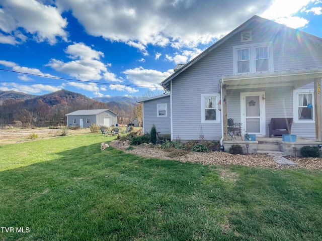 exterior space featuring a porch, a mountain view, and a front lawn